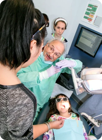 A provider speaks with a patient’s mother during an exam.