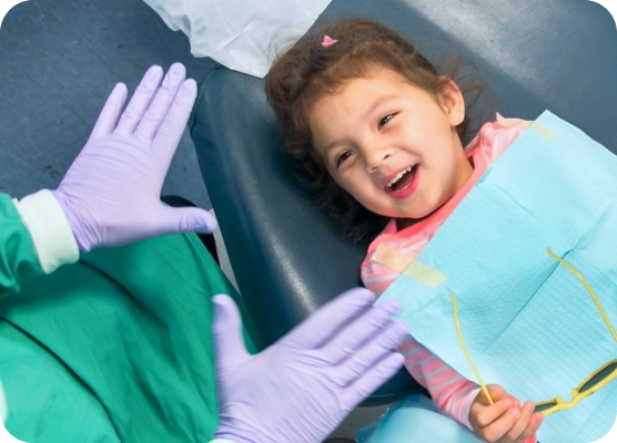 A young patient laughs in an exam chair. 