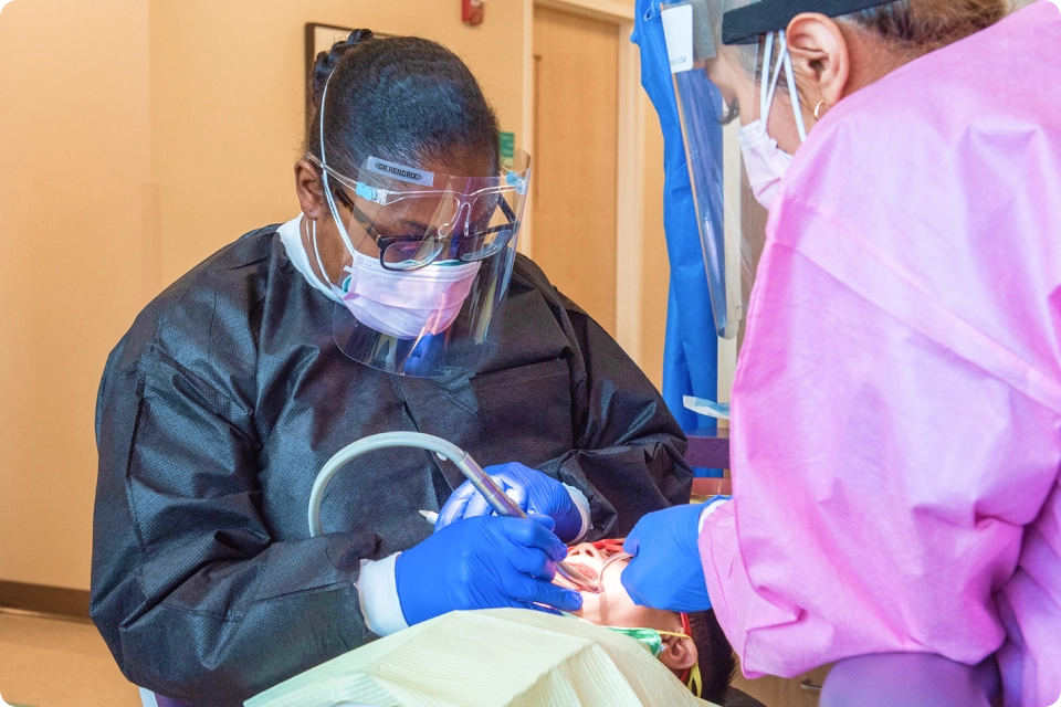 Two dental professionals working on a patient.